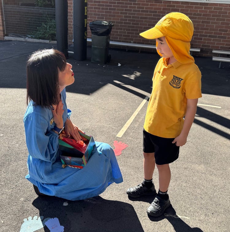 Teacher kneeling in front of a student, demonstrating compassion and support during an interaction.