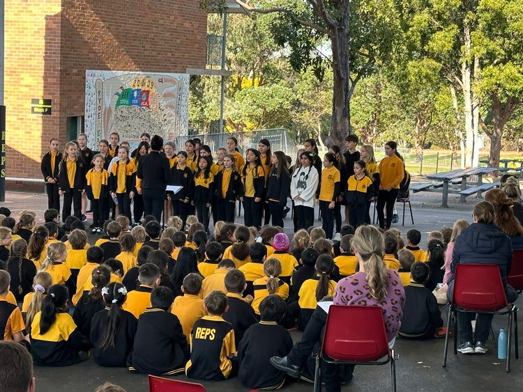 School choir performing for families during Education Week Open Day.