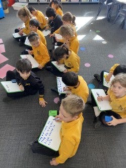 Students working on mat area using mini whiteboards