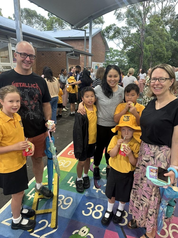 Families enjoying time together in the outdoor COLA area during the school’s Open Day, celebrating community and connection.