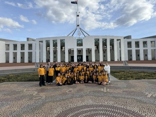 Class group sitting on the steps in front of Parliament House during the Canberra excursion